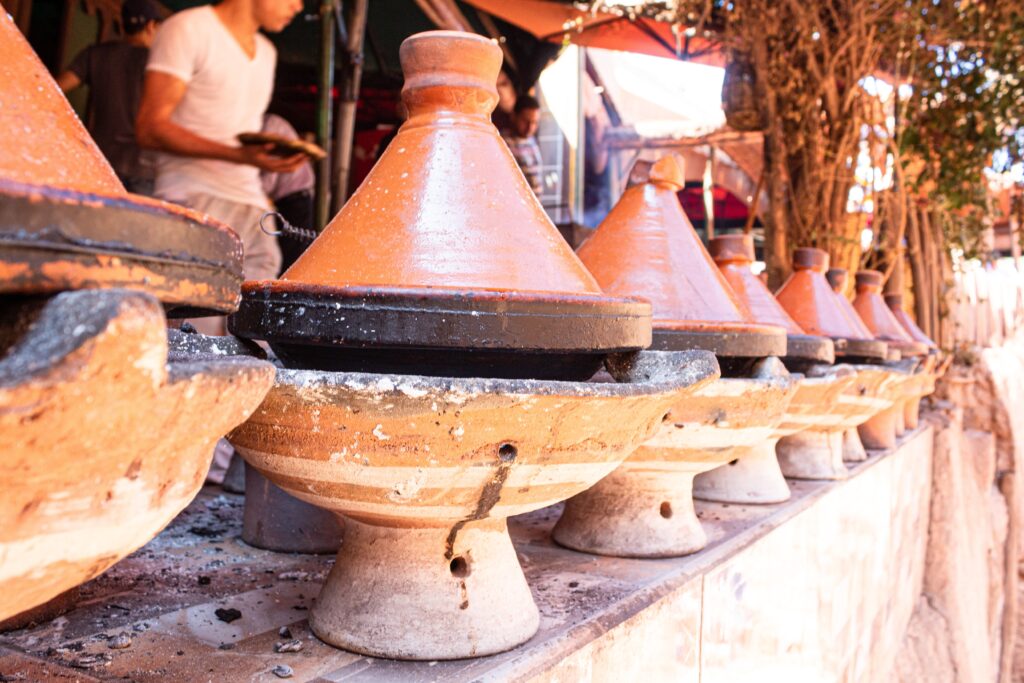 Plusieurs tajine qui sont en train de cuire sur le charbon à Taghazout près d'Agadir